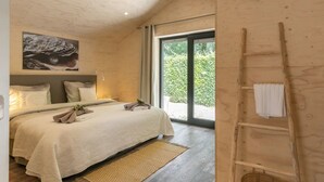 A bedroom with a bed, a headboard, a painting, a window, and a wooden ladder. - Nice Holiday Home in Kortgene With Garden (Kortgene)