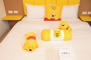 A hotel room with a bed, two Winnie the Pooh plush toys, a pillow with Winnie the Pooh's face, and a white towel on the bed. - Weclome the sun enjoy the moon B&B (Kaohsiung)