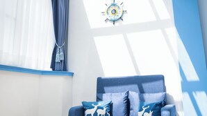 A modern room with a blue sofa, a white table, and a large window with curtains. - Weclome the sun enjoy the moon B&B (Kaohsiung)