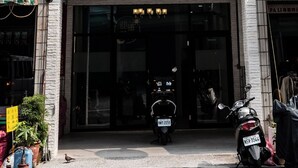 A multi-story building with air conditioning units, a storefront with a sign, and a motorcycle parked outside. - Weclome the sun enjoy the moon B&B (Kaohsiung)