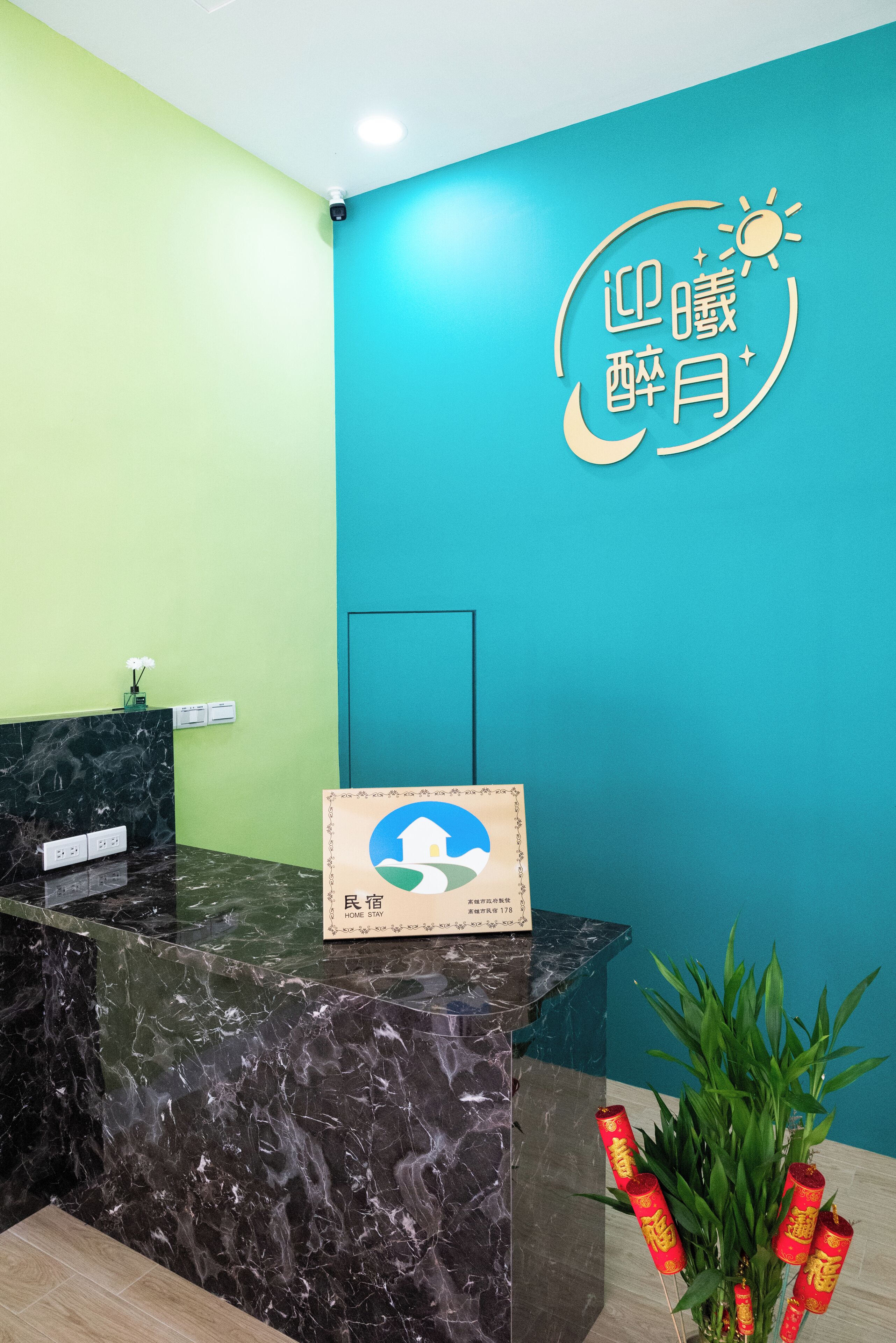 A reception desk with a teal wall and a sign with Chinese characters.