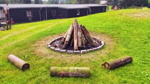 A circular fire pit surrounded by a brick border on a grassy lawn. - "sporthütten Nassau" Ihr Zentrales Domizil an der Blockline (Frauenstein)