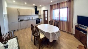 A compact living space with a kitchen, dining area, and a TV. - Apartment Tre Pini 2 with sea view (Umag)