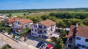 A residential area with buildings, a parking lot, and a green landscape in the background. - Apartment Christine 1 with one bedroom (Umag)