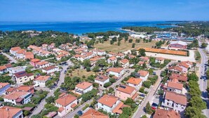 An aerial view of a coastal residential area with houses, roads, and a beach in the background. - Apartment Christine 1 with one bedroom (Umag)