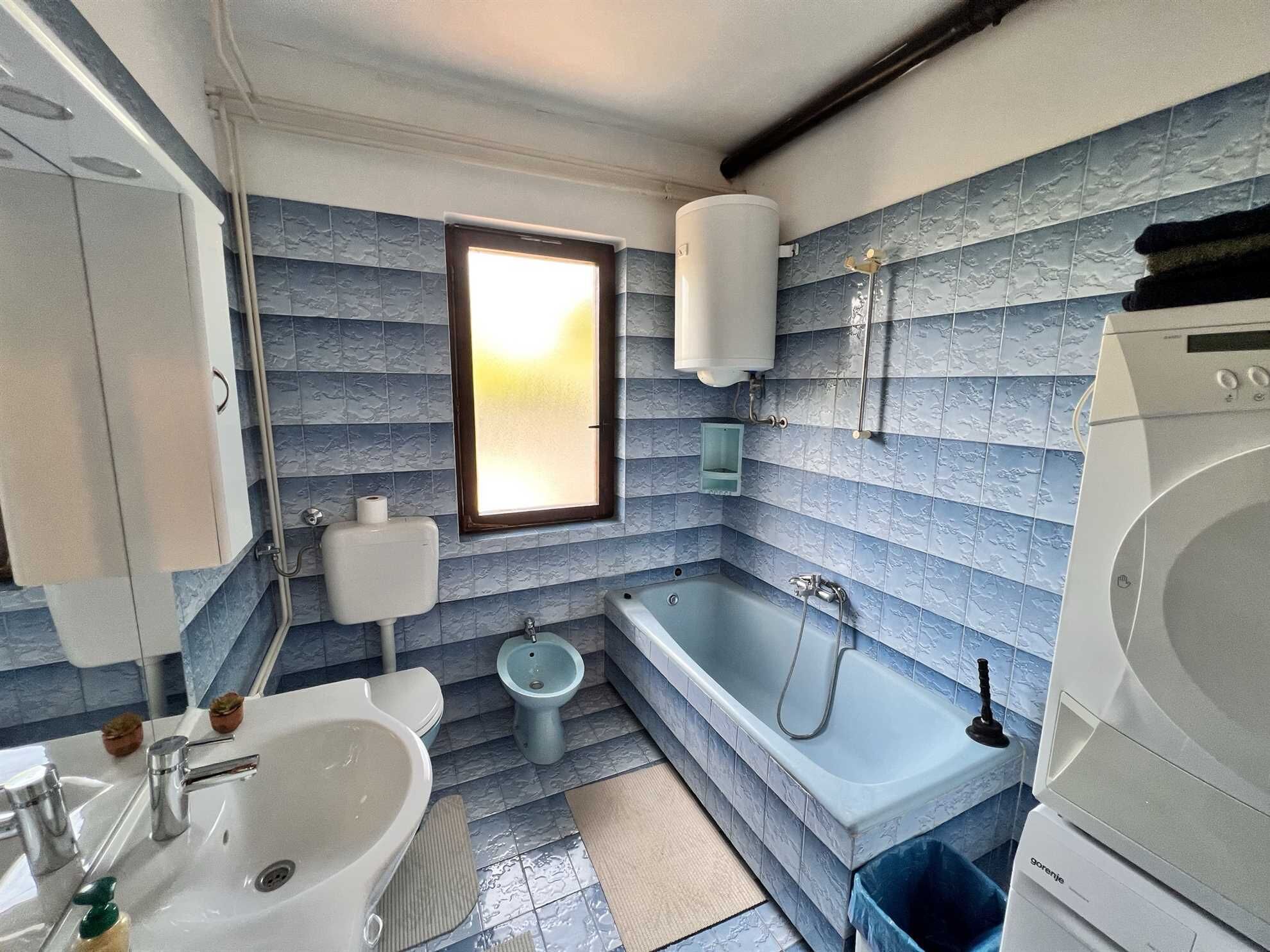 A modern bathroom with a bathtub, sink, and toilet.