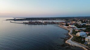 A coastal town with a marina, buildings along the waterfront, and a clear view of the sea.