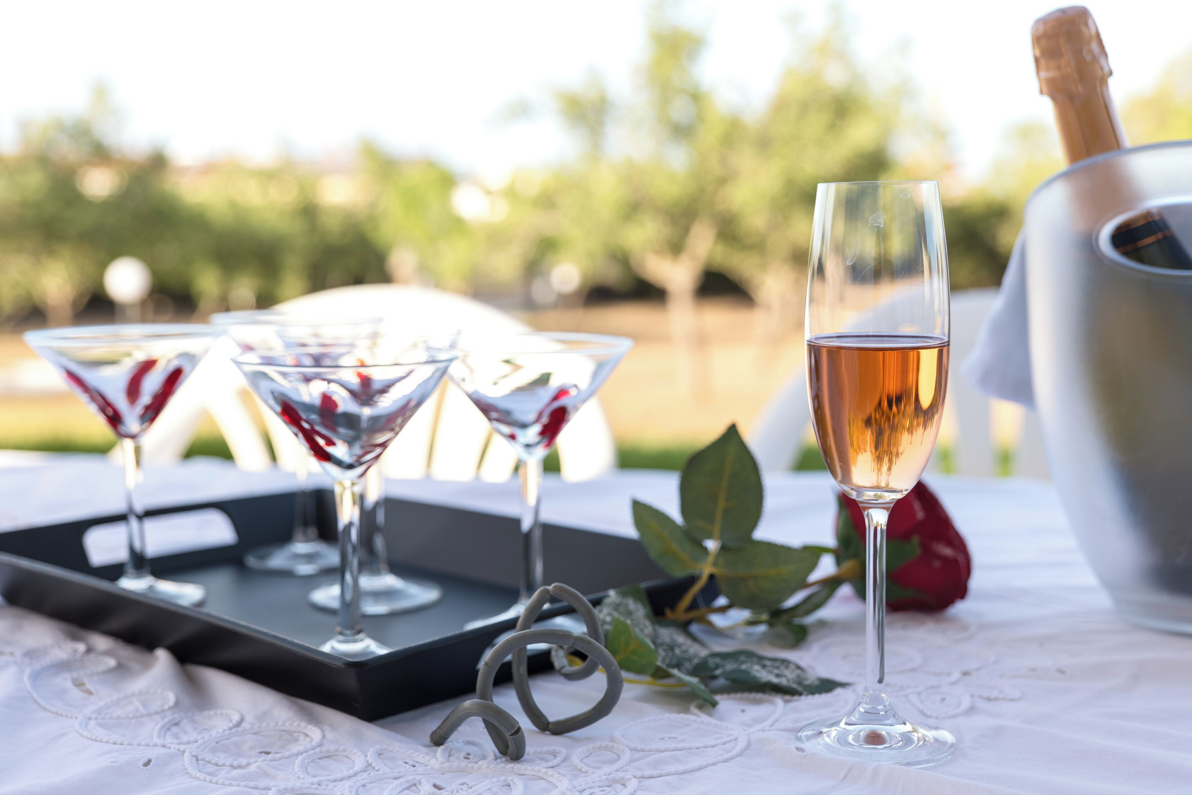 A table with champagne glasses, a bottle, and a tray.