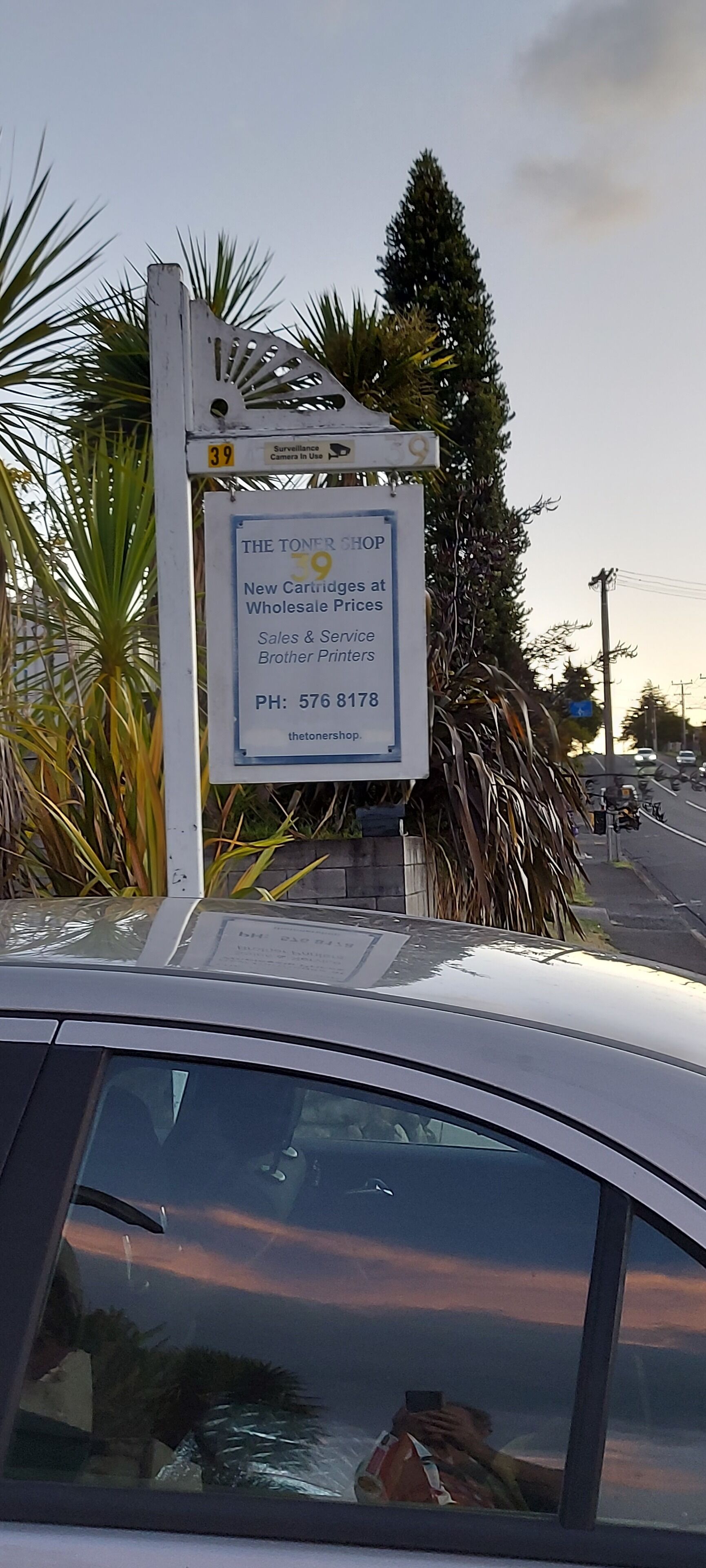 Une enseigne publicitaire pour « The Toner Shop », avec les coordonnées de l’entreprise.