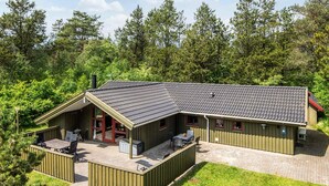 A lodge with a covered patio, outdoor seating, and a small kitchen area.