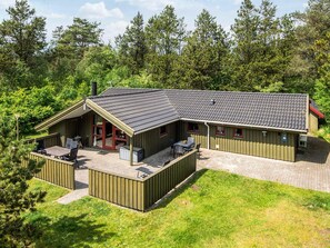 A lodge with a covered patio, outdoor seating, and a small kitchen area. - 8 Person Holiday Home in Norre Nebel (Norre Nebel)