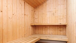 A sauna room with wooden walls and benches.