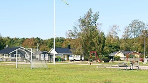 A playground with a soccer goal, swings, and benches. - 4 Star Holiday Home in Skummeslovsstrand (Skummesloevsstrand)