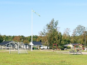 A playground with a soccer goal, swings, and benches. - 4 Star Holiday Home in Skummeslovsstrand (Skummesloevsstrand)
