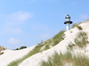 A lighthouse on a sandy hill with sparse grass. - 6 Person Holiday Home in Nexo (Nexø)