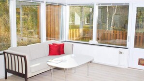 A bright room with a white sofa, a small table, and large windows. - 6 Person Holiday Home in Nexo (Nexø)