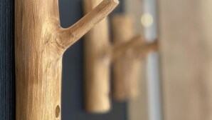 Un mur en bois avec un crochet et un objet cylindrique.