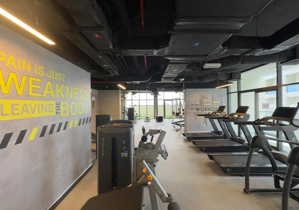 Ein Fitnessraum mit Laufbändern, Fahrrädern und Rudergeräten.