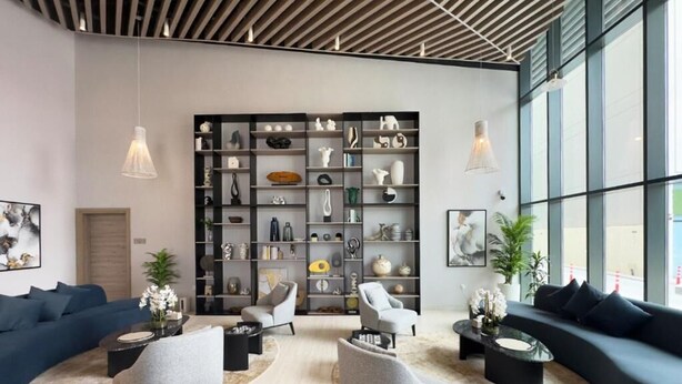Una sala moderna con una amplia estantería, dos sofás y una mesa de centro.