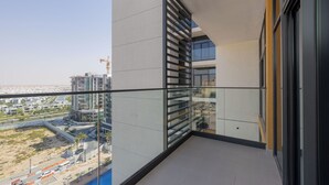 Un balcón moderno con una vista despejada del paisaje urbano, que incluye edificios y una grúa de construcción.