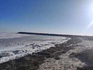 A frozen landscape with a clear sky and a distant rocky outcrop. - 10 Person Holiday Home in Storvorde (Storvorde)
