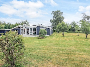 A modern house with a large glass front, a covered patio, and a well-maintained lawn. - 10 Person Holiday Home in Storvorde (Storvorde)