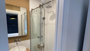 A modern bathroom with a glass-enclosed shower, a white sink, and a wooden countertop. - ¡Pisazo a estrenar en pleno centro! (Santander)