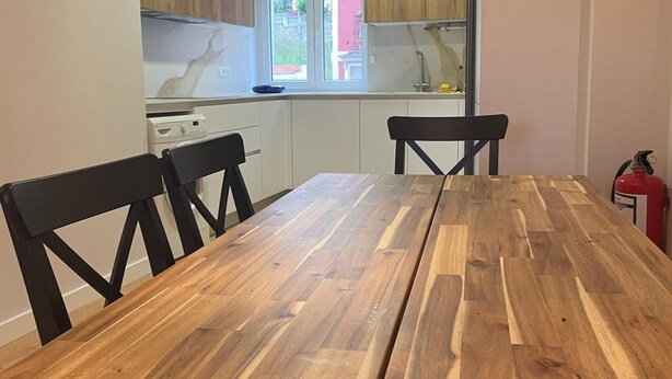 A dining table with four chairs, a kitchen in the background, and a fire extinguisher on the right. - ¡Pisazo a estrenar en pleno centro! (Santander)