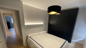 A bedroom with a bed, a wardrobe, and a pendant light. - ¡Pisazo a estrenar en pleno centro! (Santander)