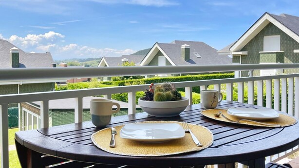 Une table à manger installée à l’extérieur, offrant une vue sur les maisons voisines.