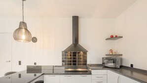 A modern kitchen with a central island, stainless steel appliances, and a pendant light.