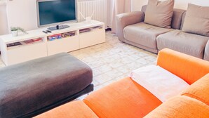 A modern living room with a flat-screen TV, a sofa, and a coffee table.