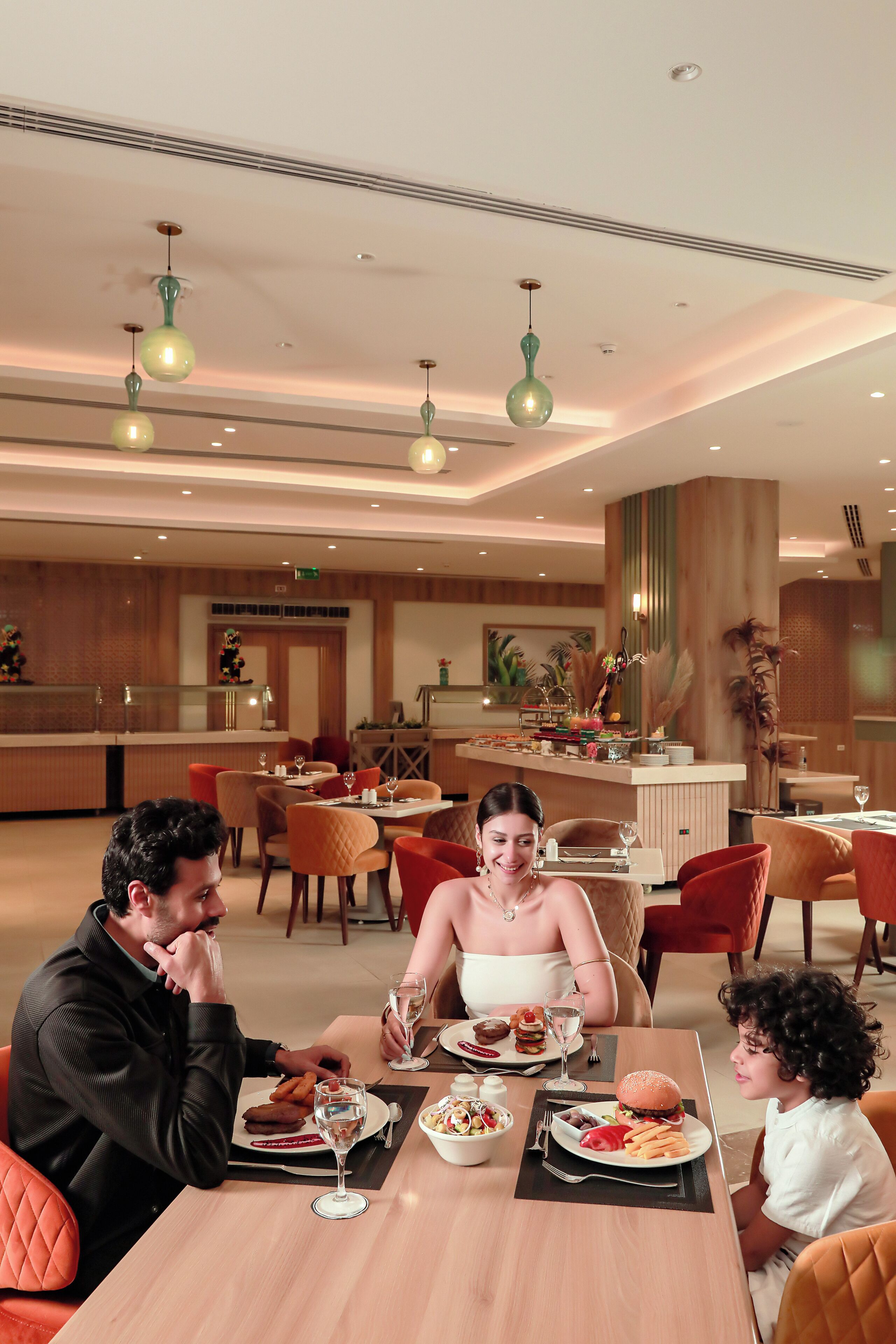 A dining area with tables, chairs, and hanging lights.