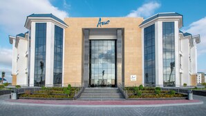 A modern building with a beige facade, large glass windows, and a sign reading "Azur". - Azur One Eleven - New Alamein (El Alamein)