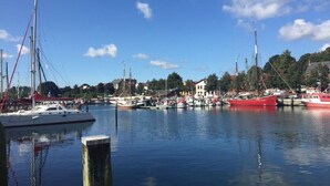 A marina with various boats docked, surrounded by buildings and trees. - Farsighted Modern Retreat (Taarstedt)