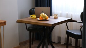 A wooden table with a laptop, a plate of fruit, and two mugs. - Elita Otel (Istanbul)