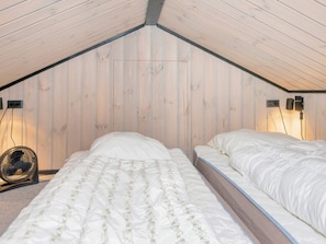 A bedroom with two beds, wooden slatted ceiling, and a standing fan. - 8 Person Holiday Home in Hejls (Hejls)