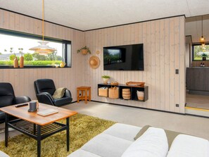A modern living room with a sofa, chairs, a coffee table, a TV, and a small side table. - 8 Person Holiday Home in Hejls (Hejls)