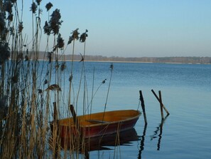 A small wooden boat tied to a dock with reeds in the foreground. - on Grimnitzsee With Lake Views (Joachimsthal)