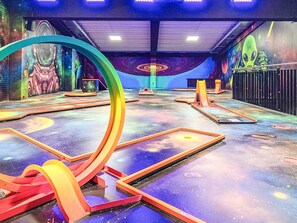 An indoor space with a futuristic design, featuring a large circular structure, a mural with space-themed artwork, and a floor with geometric patterns. - Holiday Home in Wendtorf (Wendtorf)