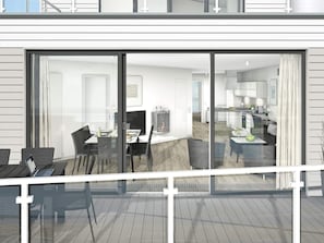 Un interior moderno con comedor, cocina y sala de estar visibles a través de grandes puertas corredizas de vidrio.