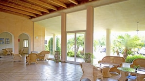 A covered outdoor seating area with wicker furniture and a tiled floor. - Futura Club La Praya (Pizzo)