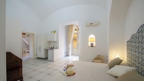 Une chambre d’hôtel équipée d’un lit, d’un bureau, d’une chaise et d’une petite kitchenette.