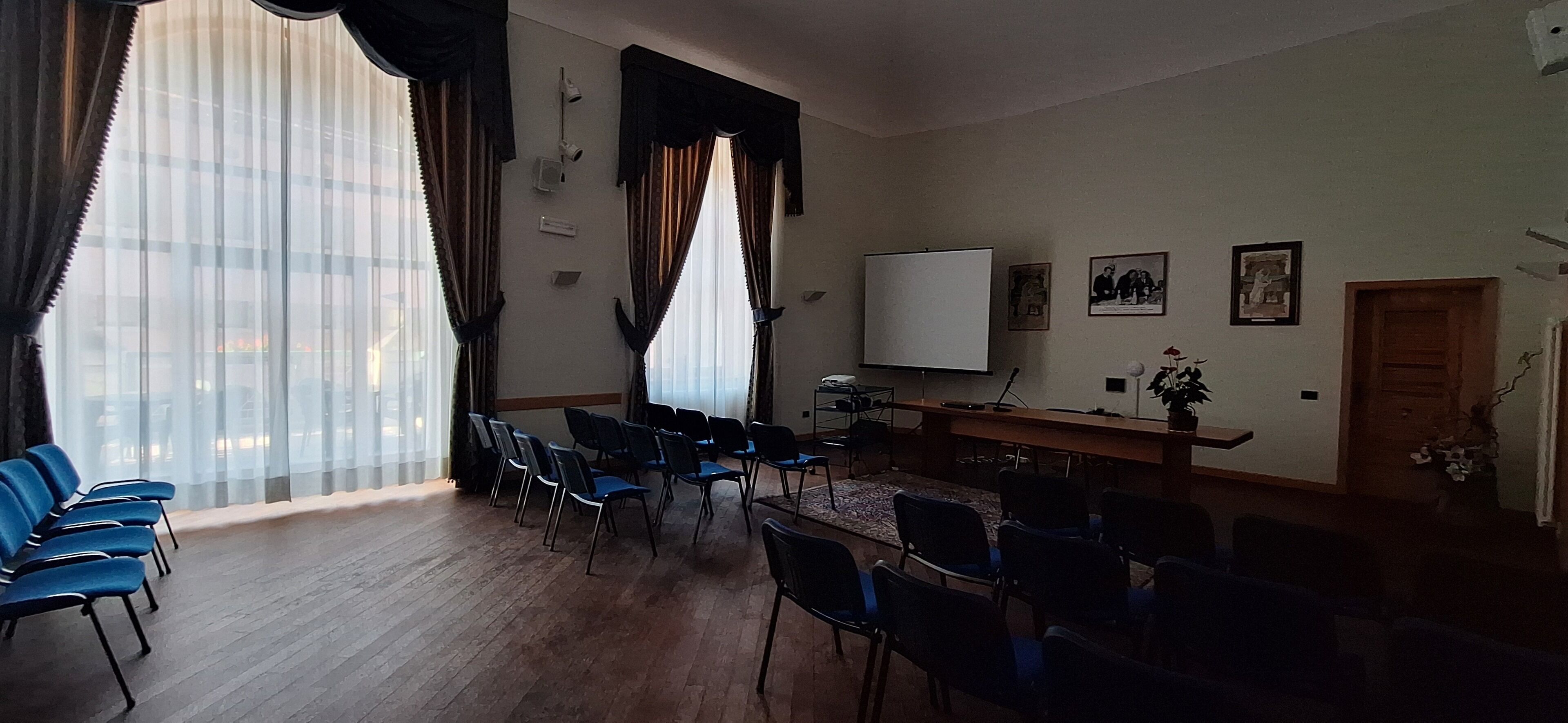 A conference room with a large table, chairs, a projector, and a whiteboard.