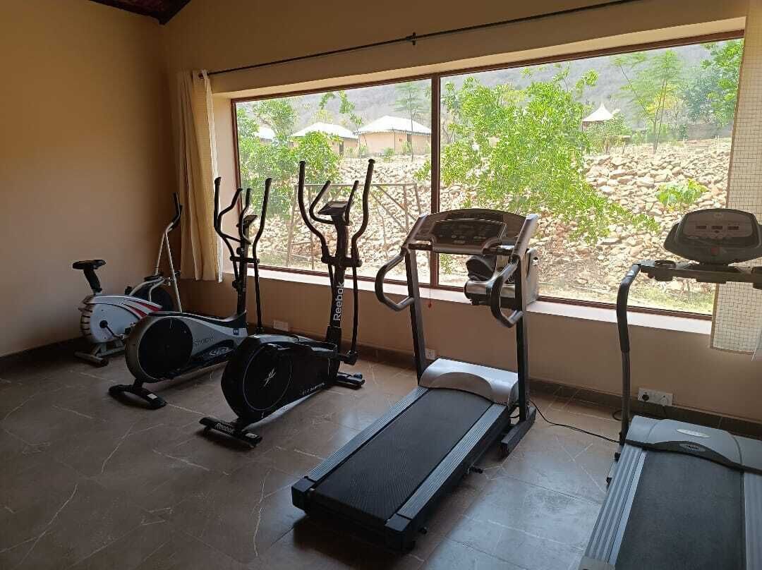 Une salle de sport équipée de tapis de course, d’appareils elliptiques et de vélos d’appartement.