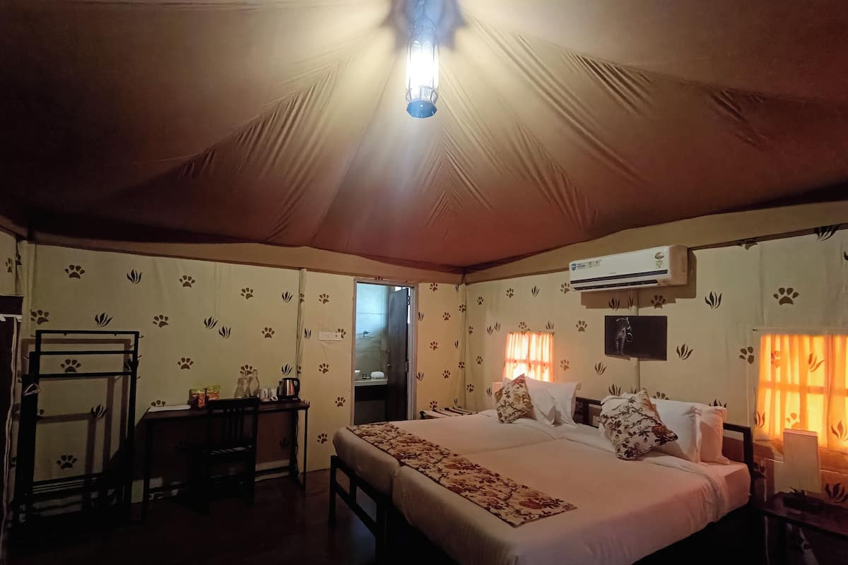 Ein Zelttyp-Raum mit einem Bett, einem Nachttisch und einer Klimaanlage.