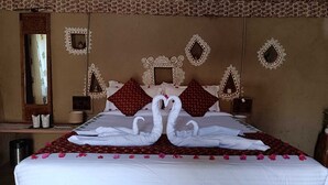 A hotel room with a large bed, decorative pillows, and wall mirrors. - Chokhiwadi Forest Retreat (Thanagazi)