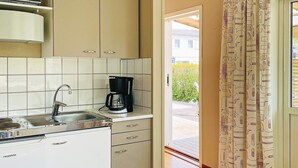 A compact kitchen with a sink, a coffee maker, and a microwave. - 2 Person Holiday Home in Ellos-by Traum (Ellos)