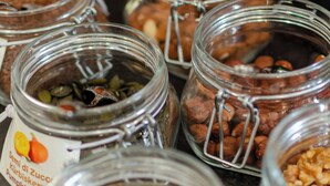 A variety of food items in glass jars, including nuts, seeds, and dried fruits. - Kyrr Smart Mountain Retreat (Moena)