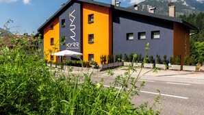 Ein modernes Gebäude vor einer Bergkulisse, beschriftet mit "KYRR SWART MOUNTAIN RETREAT".
